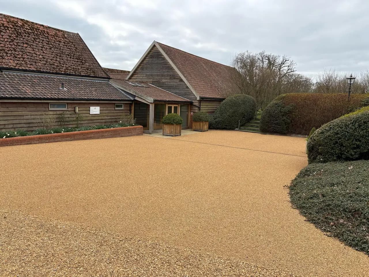 Golden stone courtyard in front of timber-clad buildings