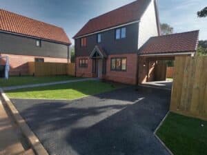 Asphalt driveway at a new-build home with a lawn
