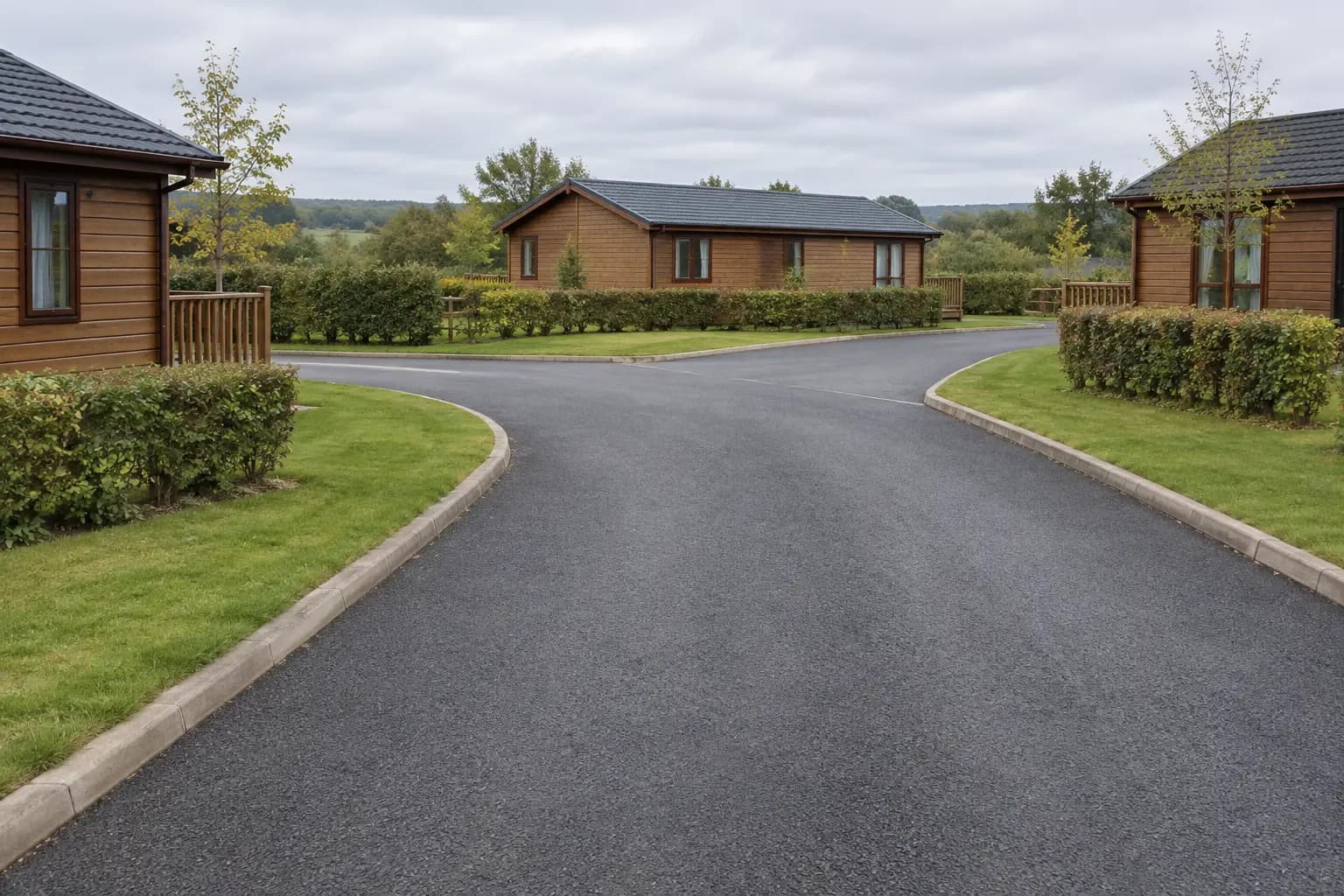 A charcoal access road between timber holiday lodges